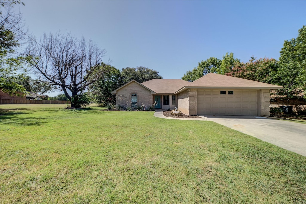 ranch-style home with a garage and a front lawn