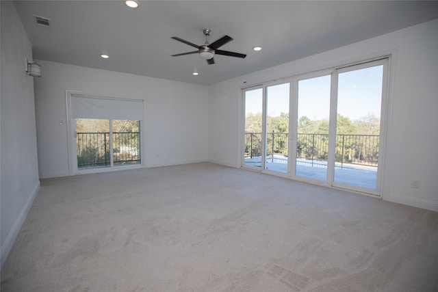 carpeted spare room featuring a healthy amount of sunlight and ceiling fan