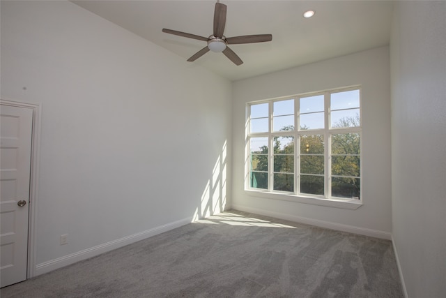 carpeted spare room featuring ceiling fan