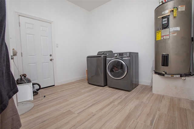 laundry area featuring electric water heater, independent washer and dryer, and light wood-type flooring