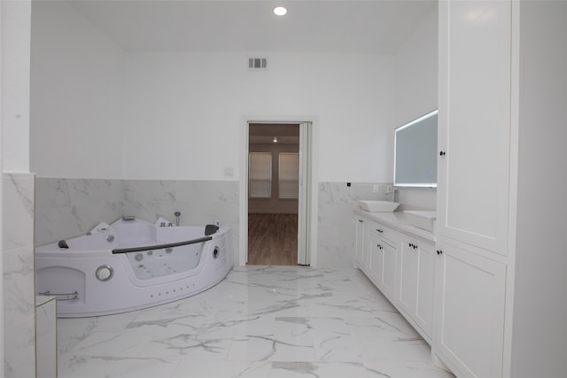 bathroom featuring vanity, tile walls, and a bathing tub