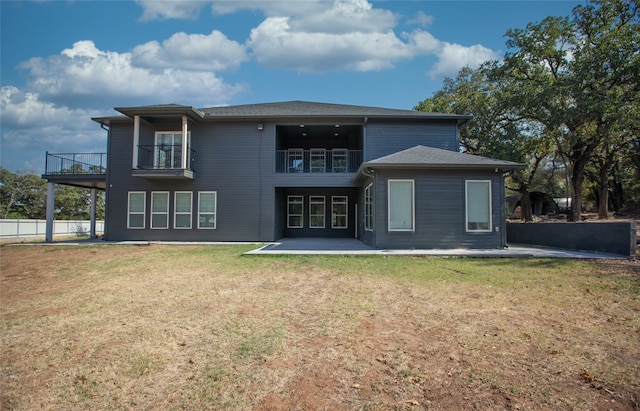 back of house featuring a patio area, a yard, and a balcony