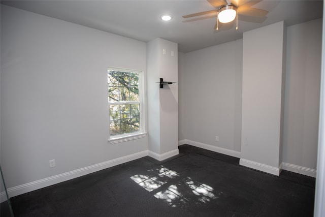 carpeted spare room with ceiling fan