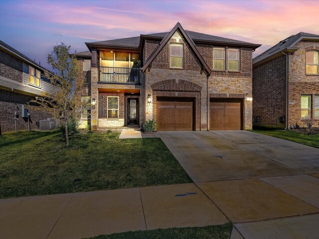 view of front of property featuring a garage, cooling unit, a lawn, and a balcony