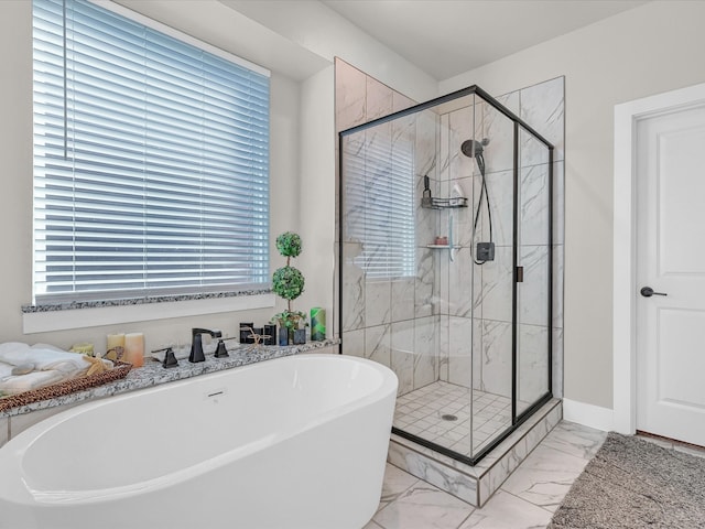 bathroom with marble finish floor, a soaking tub, a shower stall, and baseboards