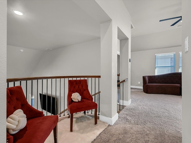 hall with lofted ceiling, carpet flooring, an upstairs landing, and baseboards