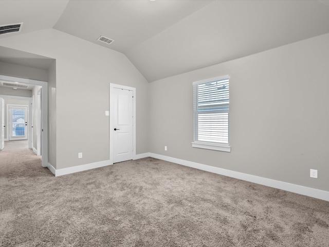 unfurnished bedroom with carpet floors, visible vents, and vaulted ceiling