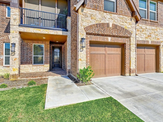 view of exterior entry featuring stone siding, brick siding, driveway, and a balcony