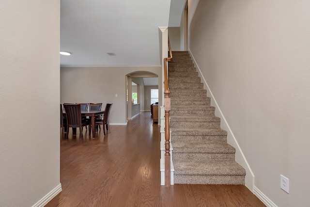 stairs with crown molding and hardwood / wood-style flooring