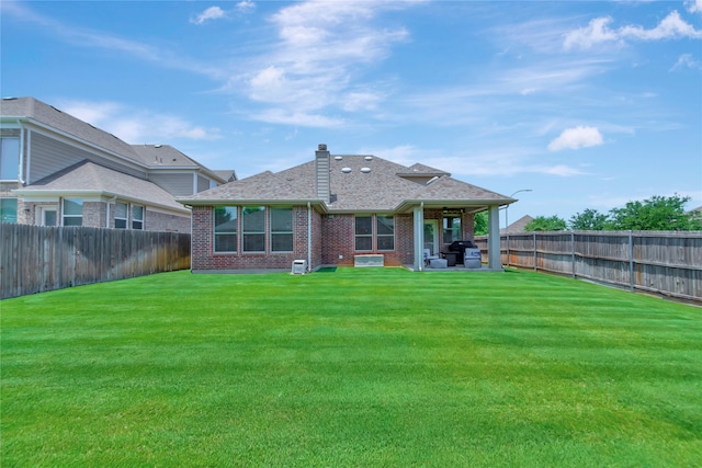 rear view of house featuring a patio area and a lawn