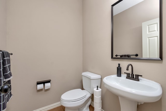 bathroom featuring toilet, sink, and tile patterned flooring