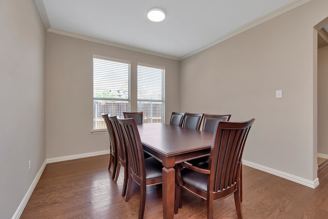 dining space with ornamental molding and dark hardwood / wood-style flooring