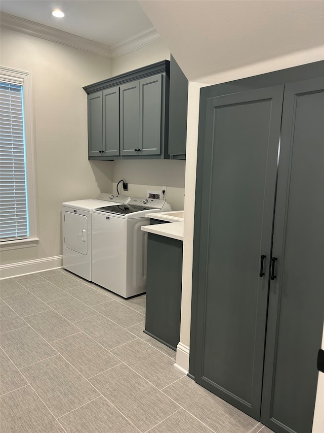 clothes washing area featuring washer and dryer, cabinets, and ornamental molding