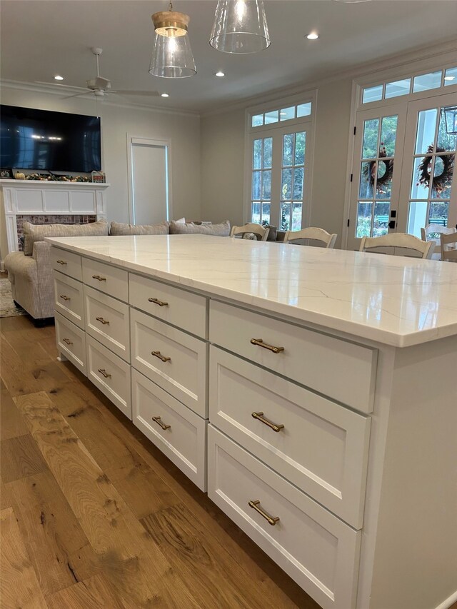 kitchen featuring backsplash, stainless steel gas stovetop, light hardwood / wood-style floors, and ventilation hood