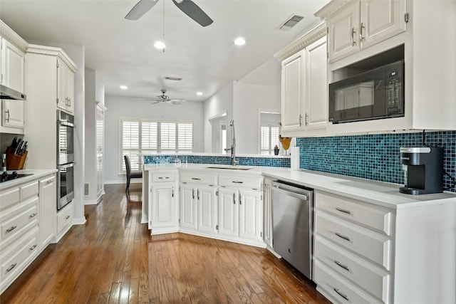 kitchen with dark hardwood / wood-style flooring, white cabinetry, black appliances, and a wealth of natural light