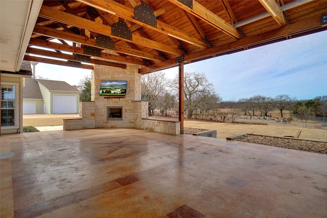 view of patio with an outdoor stone fireplace and ceiling fan