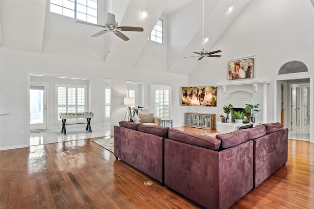 living room featuring a healthy amount of sunlight, high vaulted ceiling, and a fireplace