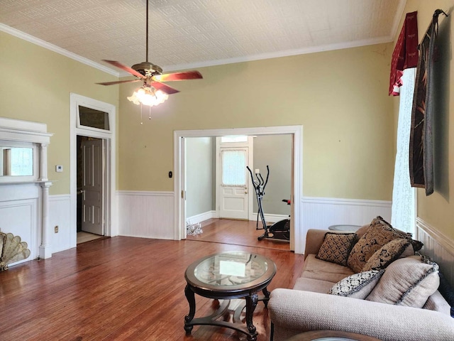 living room featuring ornamental molding, wood-type flooring, and ceiling fan