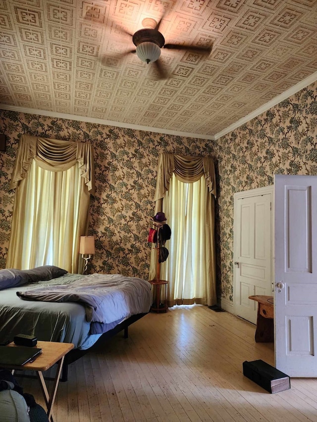 unfurnished bedroom with ceiling fan, hardwood / wood-style flooring, and crown molding