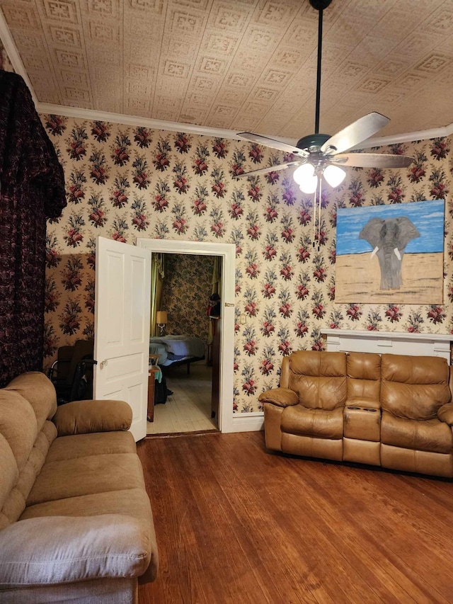 living room featuring ornamental molding, wood-type flooring, and ceiling fan