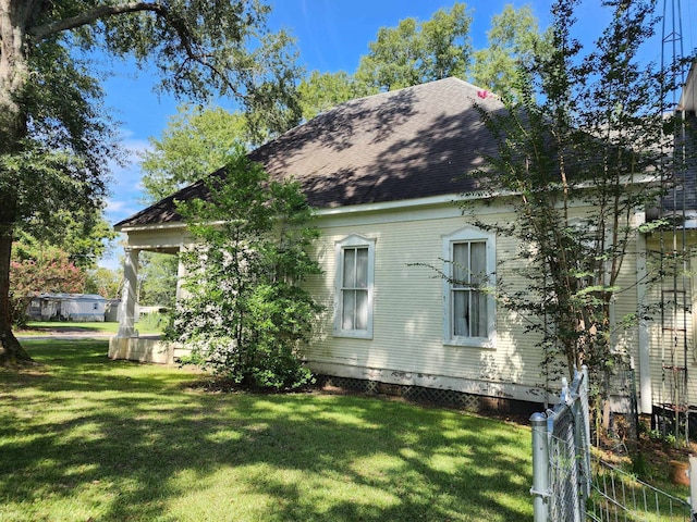 view of side of home with a yard