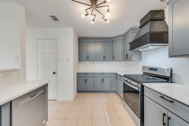 kitchen featuring light stone countertops, custom range hood, light tile patterned floors, and stainless steel appliances