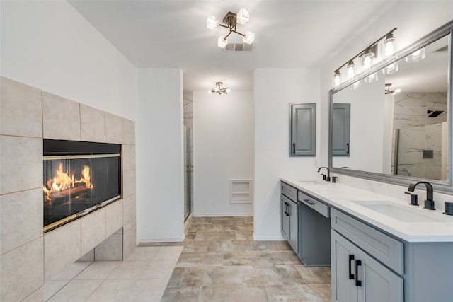 bathroom with walk in shower, vanity, and a tile fireplace