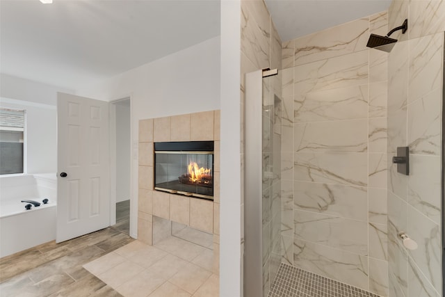 bathroom featuring a fireplace and separate shower and tub