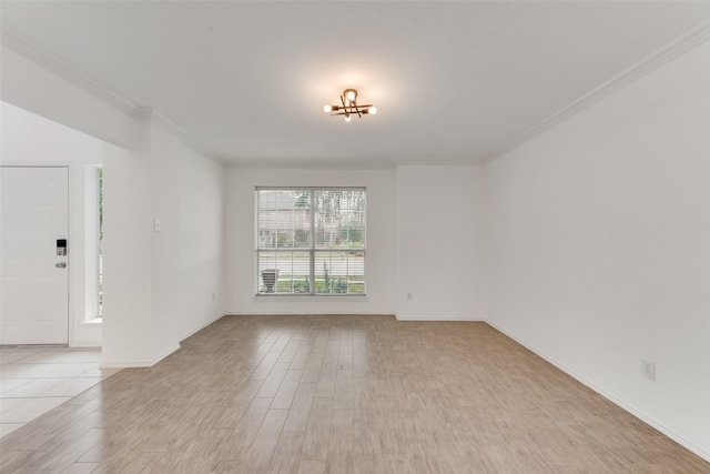 unfurnished room featuring an inviting chandelier, light hardwood / wood-style flooring, and crown molding