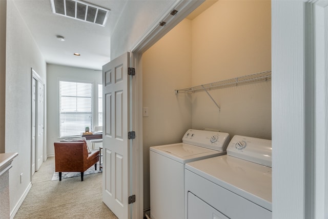 laundry room featuring light carpet and washing machine and clothes dryer