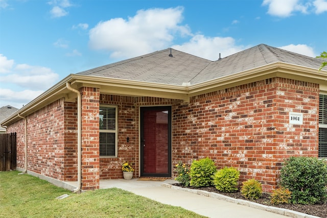 property entrance featuring a lawn