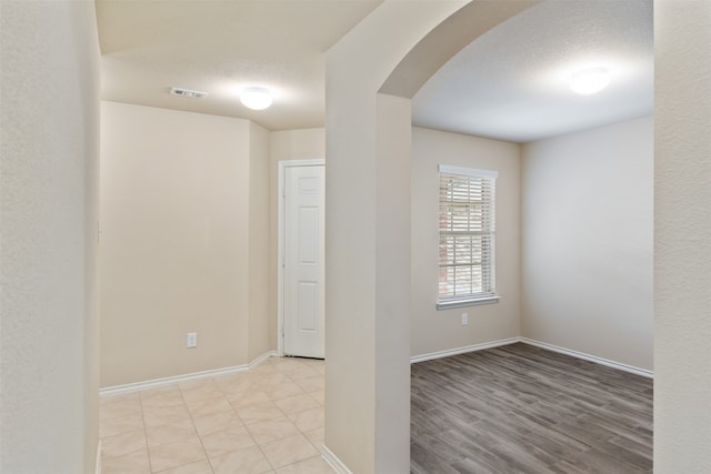 spare room with light hardwood / wood-style flooring and a textured ceiling