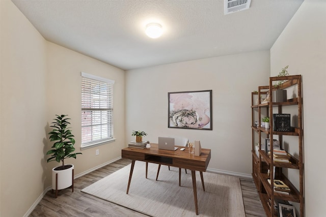 office area with hardwood / wood-style flooring and a textured ceiling