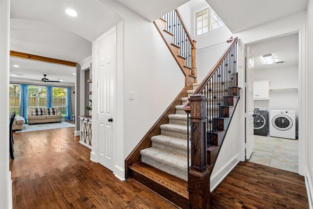 staircase with hardwood / wood-style floors, separate washer and dryer, and ceiling fan