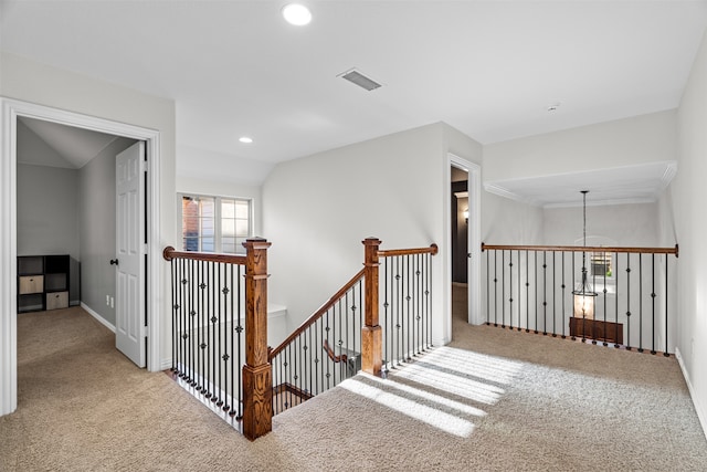 corridor with lofted ceiling, a notable chandelier, and carpet floors