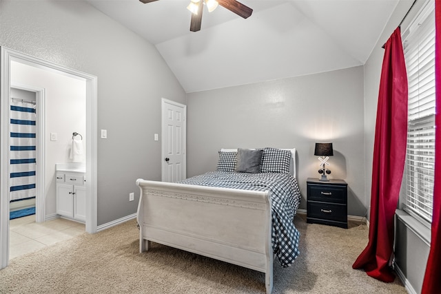 carpeted bedroom with lofted ceiling, ceiling fan, and ensuite bath