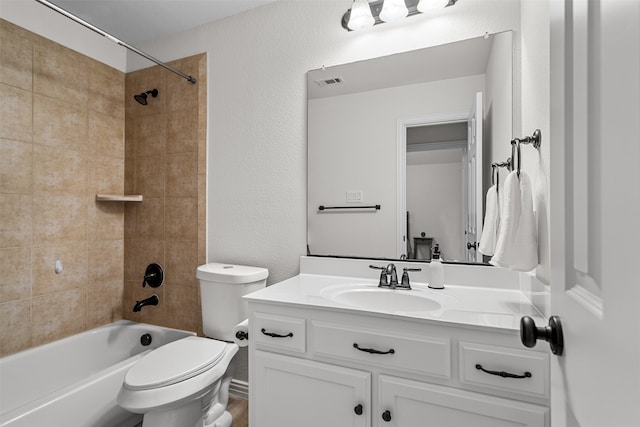 full bathroom with vanity, tiled shower / bath, and toilet