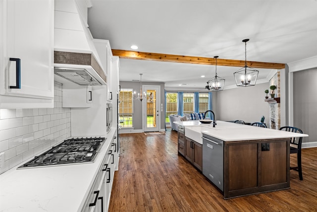 kitchen featuring stainless steel appliances, an island with sink, white cabinets, pendant lighting, and dark hardwood / wood-style flooring