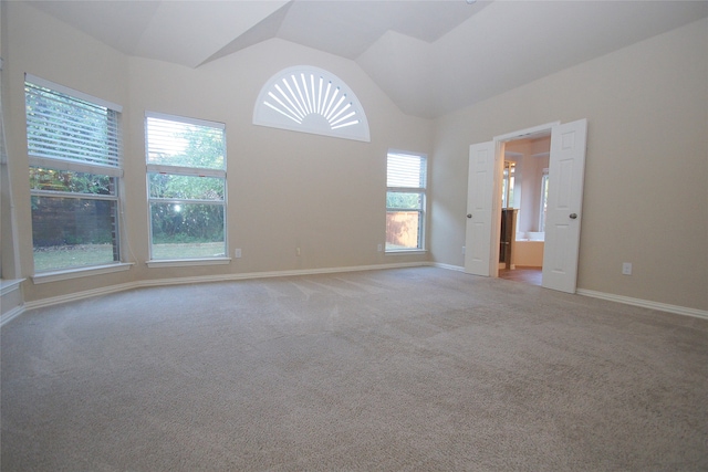 carpeted empty room featuring lofted ceiling