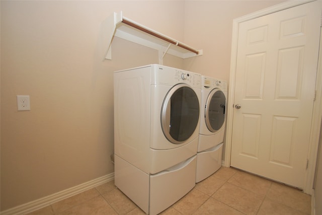 washroom with washer and clothes dryer and light tile patterned floors