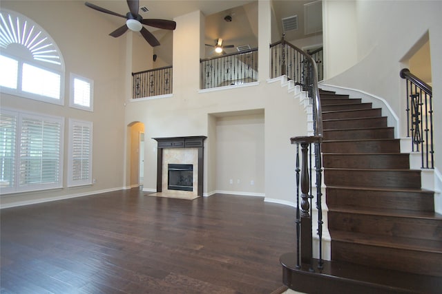 unfurnished living room with dark hardwood / wood-style floors and a towering ceiling