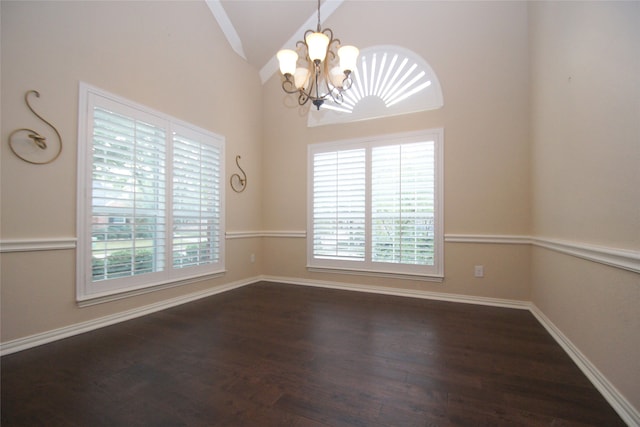 spare room featuring a notable chandelier, dark hardwood / wood-style floors, and high vaulted ceiling