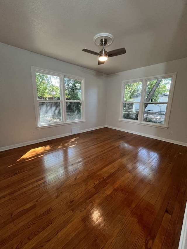 spare room with dark wood-type flooring and ceiling fan