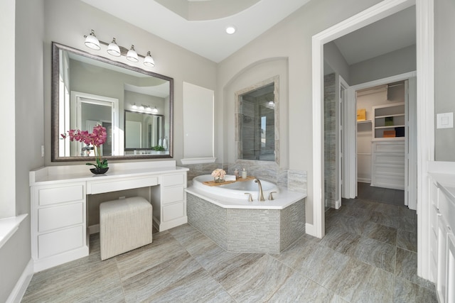 bathroom with vanity and a relaxing tiled tub