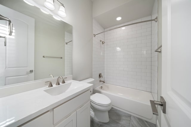 full bathroom featuring toilet, tiled shower / bath combo, and vanity