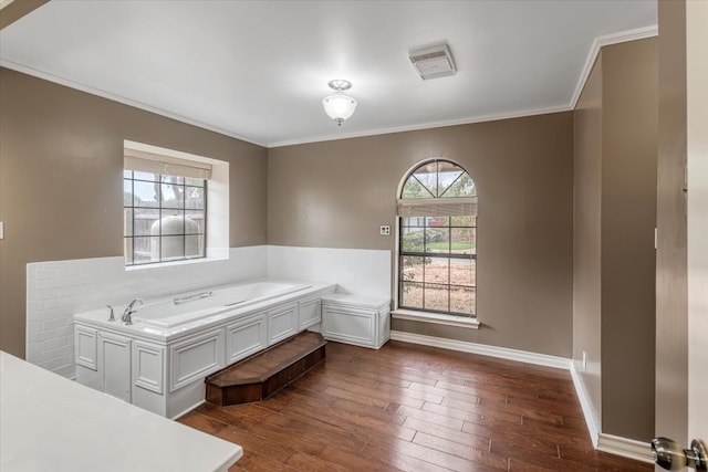 bathroom with a bath, crown molding, and hardwood / wood-style flooring