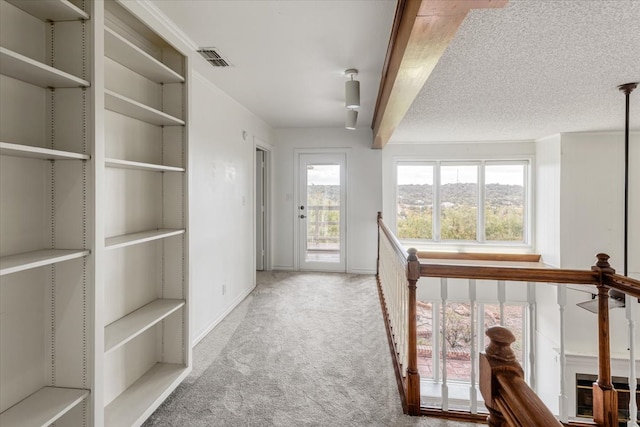 interior space featuring a textured ceiling and light colored carpet