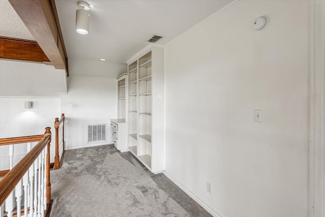 hall with beam ceiling, crown molding, carpet flooring, and built in features