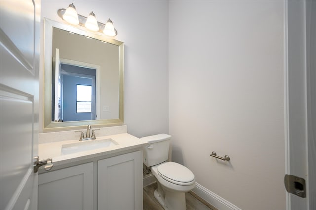 bathroom featuring hardwood / wood-style floors, vanity, and toilet