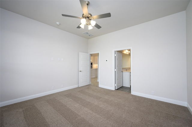 unfurnished bedroom with ceiling fan, carpet floors, and connected bathroom